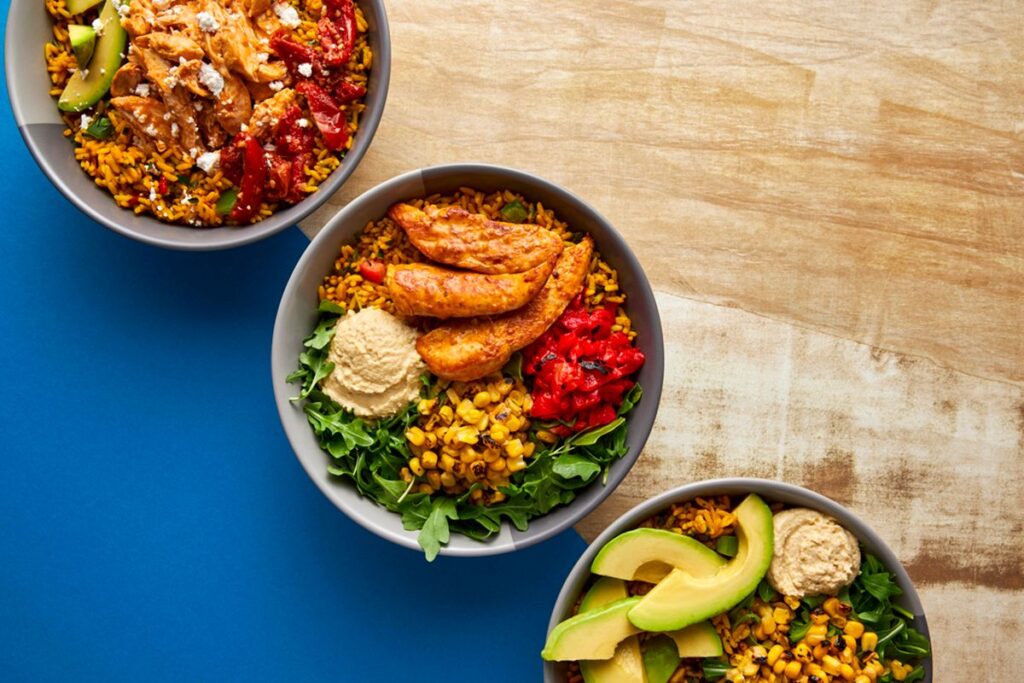 Bowls of Nando's offerings laid out on a table, soon to be available at High Street in Perimeter